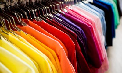 A row of colorful t-shirts hanging on a rack.Our images are processed from
